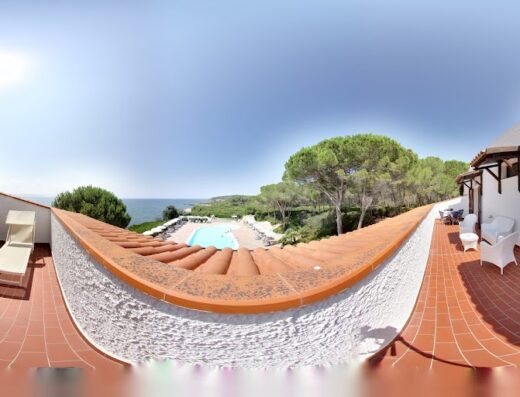 Vista panoramica dell'Hotel Punta Negra a L'Alguer/Alghero, che mostra la terrazza con lettini prendisole, la piscina e la costa. Design accogliente e vista mare per un soggiorno rilassante.