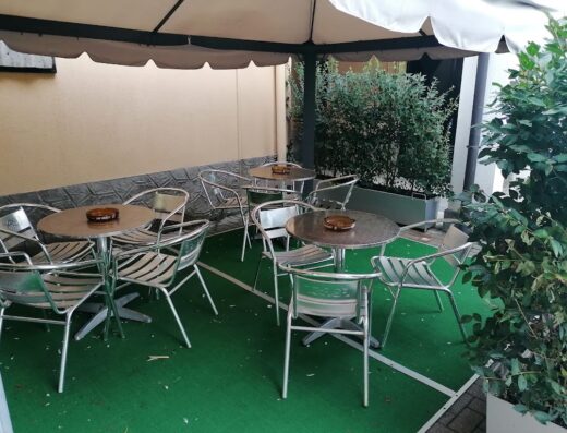 Tavoli e sedie sotto un gazebo all'Hotel Quo Vadis, spazio esterno per relax e ristorazione.
