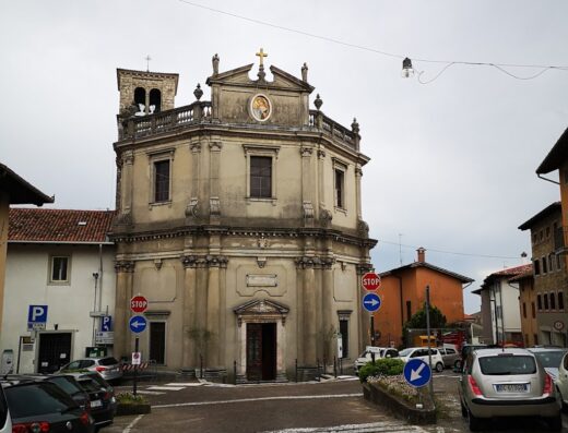 San Daniele del Friuli: Vista esterna della Chiesa di Sant'Antonio Abate, con architettura storica, parcheggio e segnaletica stradale.