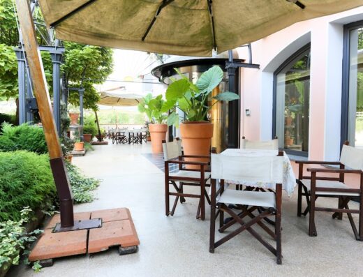 Esterno dell'Hotel Sporting, bike hotel con centro benessere e piscina panoramica, con tavoli e sedie sotto gli ombrelloni.