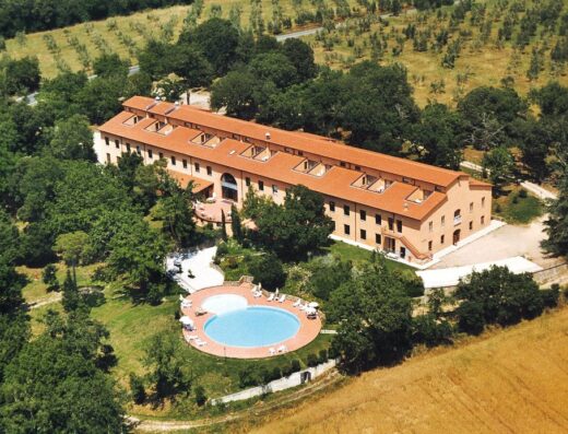 Vista aerea dell'Hotel Toscana Verde con piscina, circondato da alberi e campi, ideale per vacanze e relax in Toscana.
