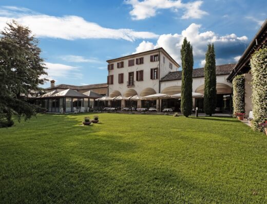 Hotel Villa Palma by AGF Hotels SRL, a beautiful Italian villa with a large green lawn, outdoor seating, and classic architecture under a blue sky