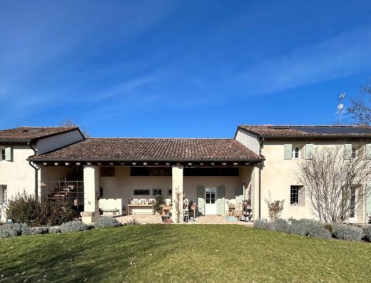 Il Glicine Natural BnB: Facciata esterna di una casa di campagna ristrutturata con tetto in tegole, pannelli solari e giardino curato in una giornata di sole.