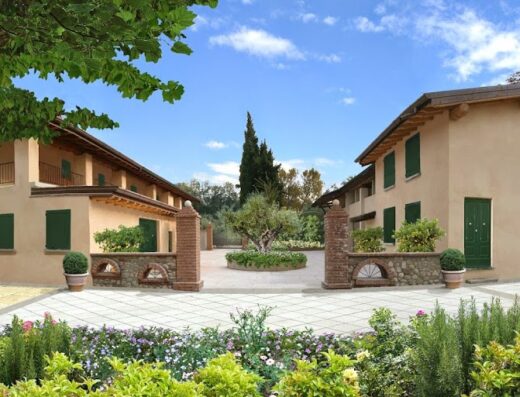 Il Podere Degli Ulivi Agriturismo: vista esterna delle case coloniche ristrutturate con giardino curato, ideale per un soggiorno rilassante in un ambiente rurale autentico.