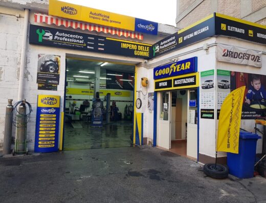 Foto dell'Autocentro Professional Impero delle Gomme, un'officina meccanica e rivenditore di pneumatici con insegne di Magneti Marelli, Checkstar, Goodyear e Bridgestone.