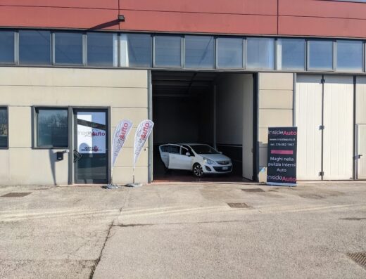 InsideAuto Treviso: Esterno dell'officina con auto bianca in lavorazione. Servizi professionali di pulizia interni auto e detailing.