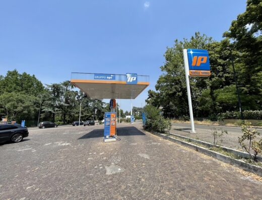 Stazione di servizio IP con insegna ben visibile e pompe di benzina. Servizi per motociclisti e automobilisti in viaggio.