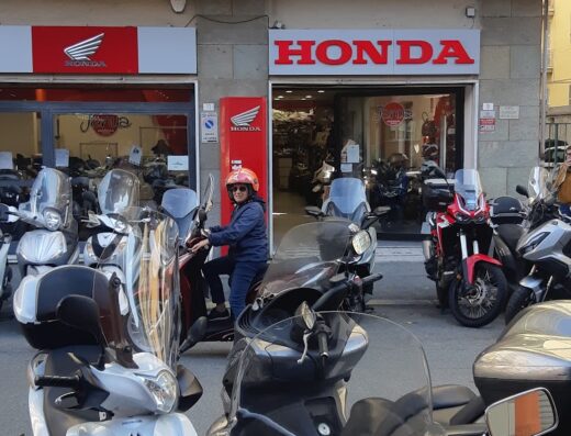 Janua Service Srl: Esposizione di moto e scooter Honda presso la concessionaria con una persona in sella a uno scooter.