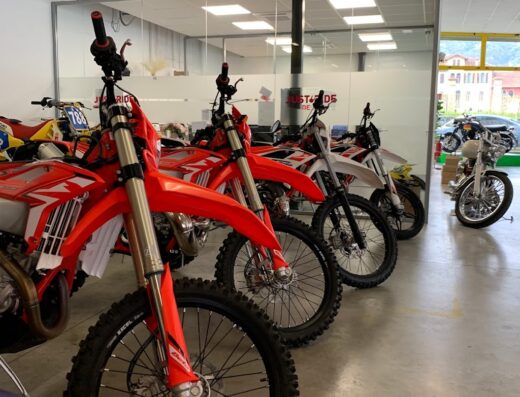 File di moto da cross rosse e bianche in vendita presso Just Ride Store, concessionario di moto e accessori per motociclisti.