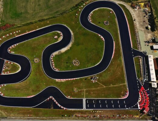 Vista aerea del circuito di karting a Roma, Italia, con curve, pneumatici di sicurezza e area di partenza. Ideale per appassionati di motori e competizioni.