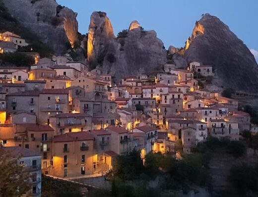 Vista suggestiva di Castelmezzano al crepuscolo, borgo medievale incastonato tra le Dolomiti Lucane, ideale per un viaggio in moto alla scoperta dei paesaggi italiani.