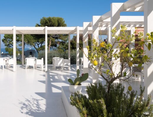 Terrazza bianca con pergolato, vista mare, tavoli e sedie bianche, piante di limoni e cactus a La Chiave dei Trabocchi.