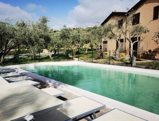 Piscina all'aperto presso La Corte degli Ulivi, albergo rurale immerso nel verde con ulivi e vista sul paesaggio circostante.