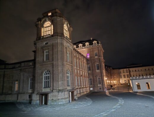 La Finestra sulla Reggia: view of the Reggia di Venaria Reale at night, showcasing its architectural details and illuminated windows.