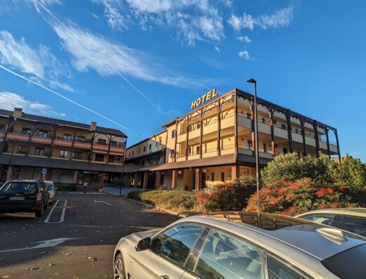 La Locanda della Franciacorta: vista esterna dell'hotel e del parcheggio con auto in primo piano, ideale per motociclisti in viaggio.