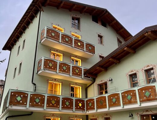 La Valle del Gran Sasso Hotel Residence: Facciata esterna dell'hotel con balconi in legno decorati e finestre illuminate, tipica architettura montana italiana.