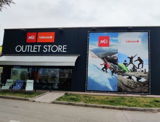 Lafuma Outlet Store building exterior featuring Millet and Lafuma branding, outdoor adventure imagery, and patio furniture display, promoting outdoor gear and apparel.