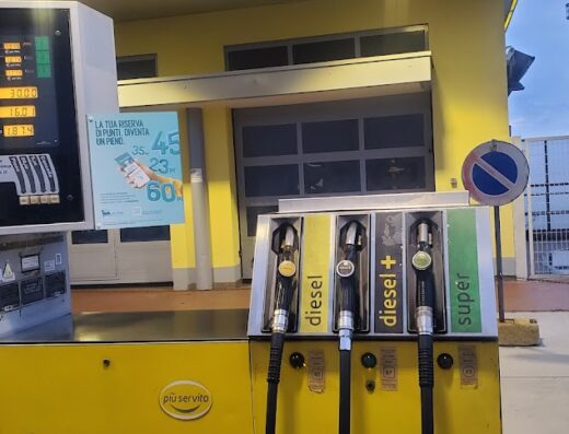 Distributore di carburante giallo con pompe per diesel, diesel+ e super. Prezzi visualizzati. Ideale per rifornimento moto durante viaggi e tour.