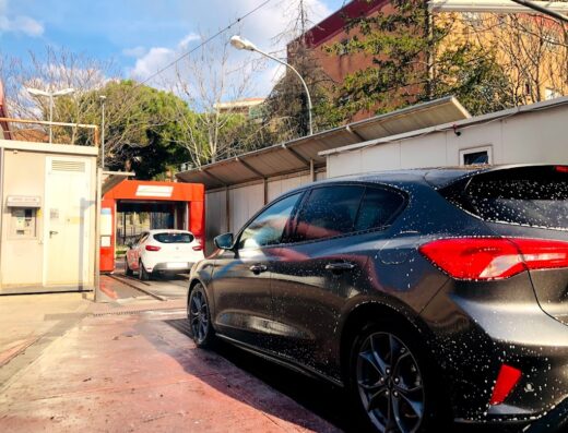 Lavaggio auto a Perugia Prepo: un'auto scura con schiuma di sapone è in attesa, mentre una bianca è all'interno dell'autolavaggio.