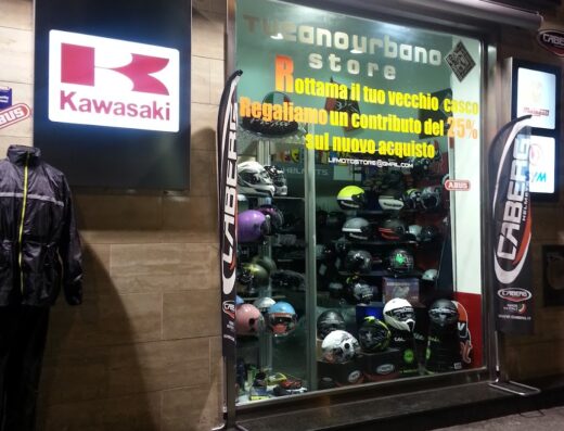 Negozio di ricambi e accessori moto con vetrina espositiva di caschi Caberg e insegna Kawasaki, offerte su rottamazione caschi.