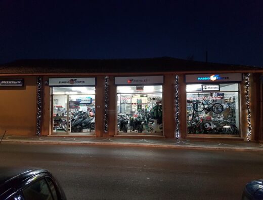 Archilletti G. Sas: concessionaria moto con vetrine illuminate che espongono moto Piaggio, accessori Shoei e bici Bianchi. Servizi di vendita e assistenza.