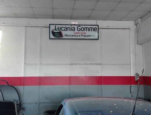 Insegna di Lucania Gomme, centro auto specializzato in meccanica e pneumatici, all'interno di un'officina.