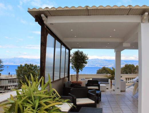 Terrazza panoramica dell'Hotel Lungomare con vista mare, arredamento da esterno e piante ornamentali, ideale per relax e vacanze.