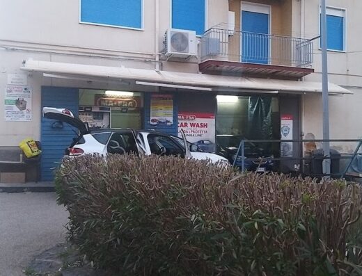Ma Fra Car Wash: vista esterna dell'autolavaggio con auto in attesa di lavaggio e insegna ben visibile.