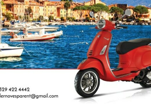 Noleggio Vespa a Maderno: elegante scooter rosso con vista panoramica sul lago di Garda, ideale per esplorare la zona con stile e libertà.