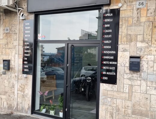 La facciata del negozio Maggiore Moto SAS, rivenditore di moto plurimarca. Insegna ben visibile con logo e marchi trattati: Aprilia, BMW, Ducati, Harley Davidson e altri. Servizi di vendita e assistenza moto.