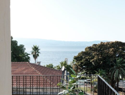 Vista dal balcone a Malalbergo sul lago con palme e alberi. Ispirazione di viaggio e vacanza in Italia.