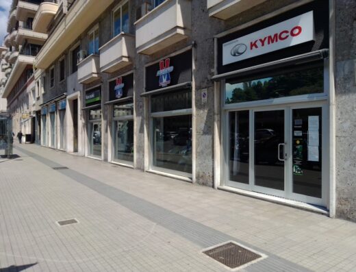 Marchald Motorrader: Facciata di un negozio di concessionaria moto Kymco e Kawasaki con vetrine sulla strada, servizi di vendita moto e accessori.