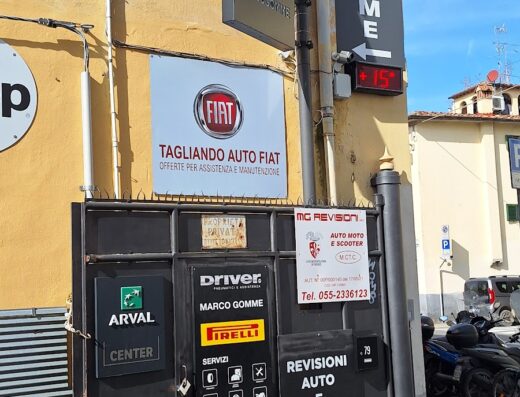 Foto dell'entrata di Marco Gomme, officina specializzata in pneumatici e servizi per auto e moto, inclusi tagliandi Fiat, revisioni e assistenza ARVAL. Si vedono insegne di Driver, Pirelli e un display con la temperatura.