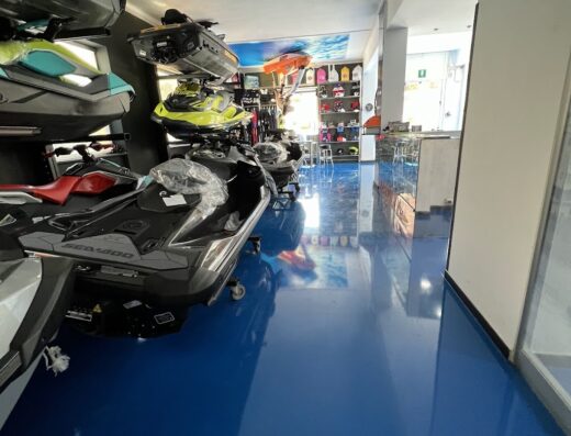 Showroom di Maremoto Genova Srl con esposizione di moto d'acqua Sea-Doo e accessori per sport acquatici, pavimentazione blu lucida