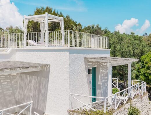 Marenea Suite Hotel 5 stelle CDSHotels: Vista esterna di una suite con terrazza solarium, gazebo bianco con tendaggi e lettino prendisole.