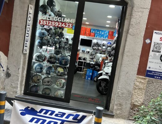 Negozio Mary Moto a Napoli, specializzato in noleggio scooter e vendita accessori moto. Vetrina con caschi e cartello promozionale scooter rent.