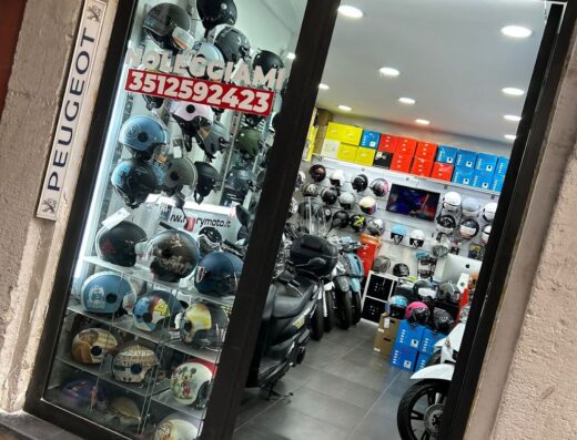 Vetrina del negozio Mary Moto che offre servizi di noleggio scooter e vendita di accessori moto, tra cui caschi di diverse marche e modelli.