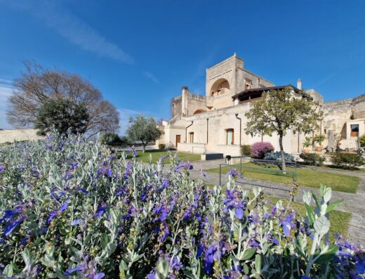 Masseria Santa Lucia vista esterna con fiori in primo piano, Puglia, Italia
