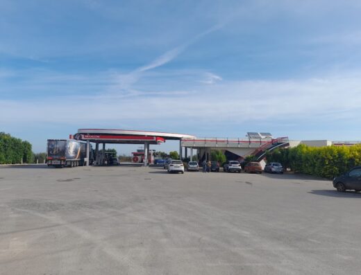 McGallon service station with cars and a truck parked under the canopy, offering fuel and services for travelers on the road.