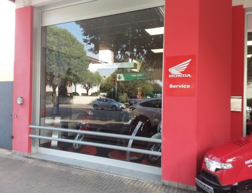 Showcase di MCR Group Honda Pordenone con moto e servizi Honda visibili attraverso la vetrina, logo Honda Service in evidenza.