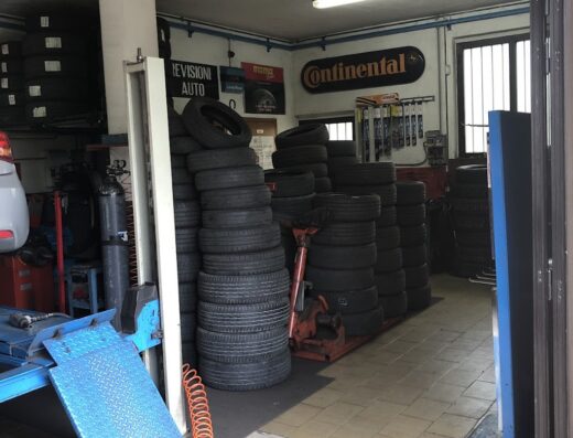 Interno di Melani Gomme, officina specializzata in pneumatici per auto e moto, con scaffali di gomme Continental e attrezzatura per la revisione.