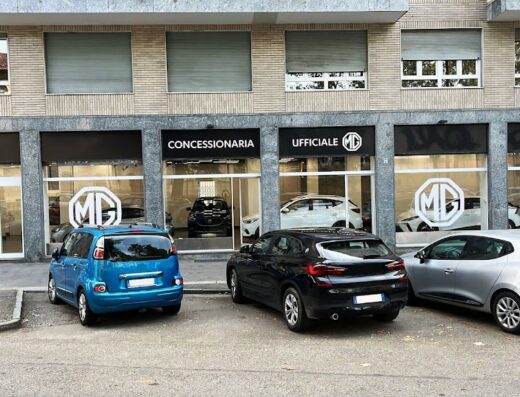 MG STORE: Concessionaria ufficiale MG a Torino del Gruppo MO.VI S.p.A., con auto MG esposte in vetrina e parcheggiate di fronte all'ingresso.