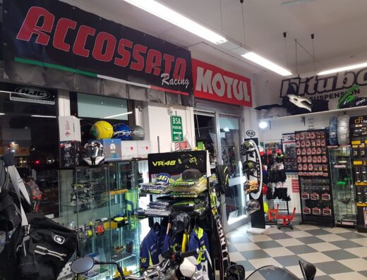 Interno del negozio MikeMoto con esposizione di caschi, abbigliamento moto, accessori, ricambi e banner Accossato Racing e Motul