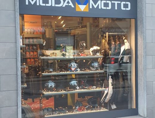 Vetrine del negozio Modamoto con esposizione di caschi, occhiali e abbigliamento da moto. Accessori e articoli per motociclisti e amanti del viaggio su due ruote.