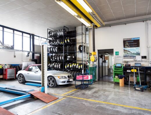 Officina Morescalchi Srl: Interno dell'officina con auto BMW cabriolet Z3, scaffale di pneumatici e attrezzature per la manutenzione auto.