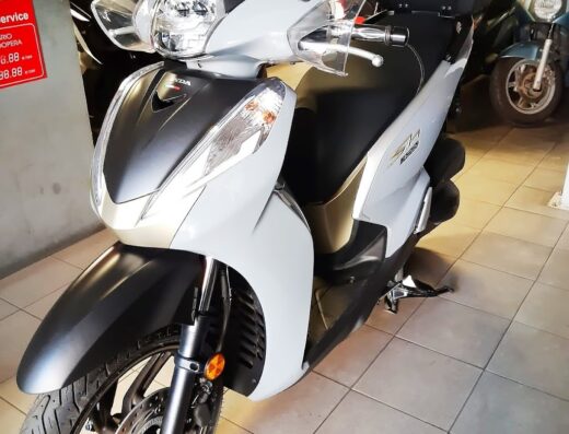 Moretti Moto: Scooter Honda SH300i bianco e nero in esposizione, ideale per la mobilità urbana e il turismo a medio raggio.