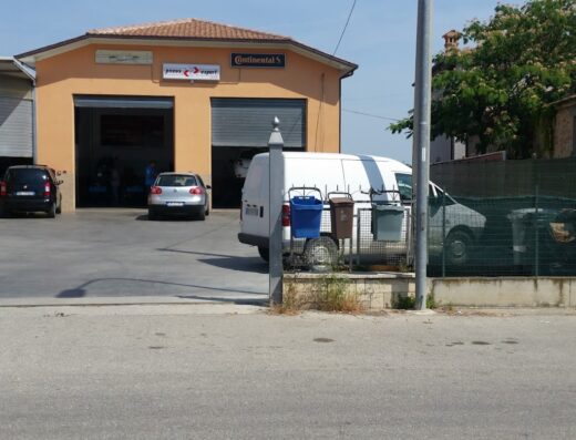 Esterno di Mosciano Gomme, officina specializzata in pneumatici Continental, con auto parcheggiate di fronte all'ingresso.