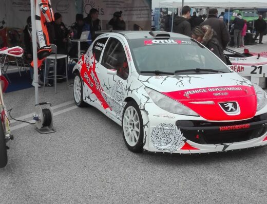 Auto da corsa Peugeot con livrea bianca, rossa e nera al Mostrascambio di Treviso, evento dedicato a moto, auto e ricambi d'epoca
