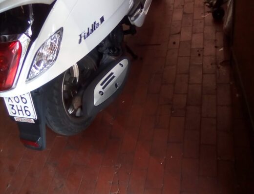 Dettaglio posteriore di uno scooter Fiddle III bianco, con targa A06 3H6, parcheggiato su un pavimento piastrellato rosso-marrone. Motauto Sas Di Giovacchini & C.