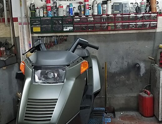 Moto Carrozzeria Angel Bike: Scooter d'epoca su piattaforma di riparazione, officina specializzata in restauro moto, verniciatura, riparazione plastiche e recupero moto su strada.